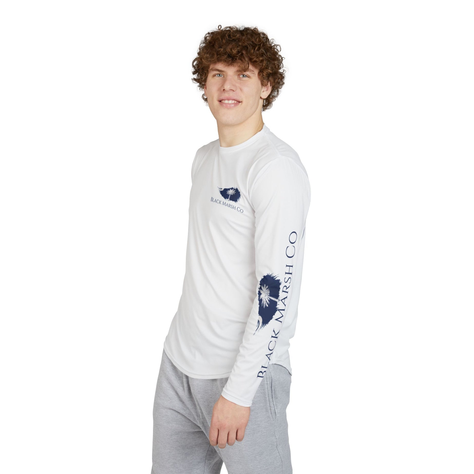 Young man wearing southern, coastal white long sleeve performance top with blue South Carolina state emblem on left sleeve 