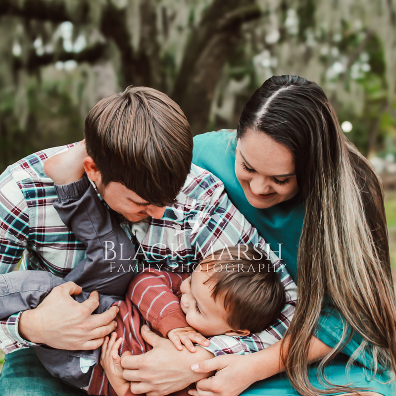 Man and woman holding a young boy in a family photograph