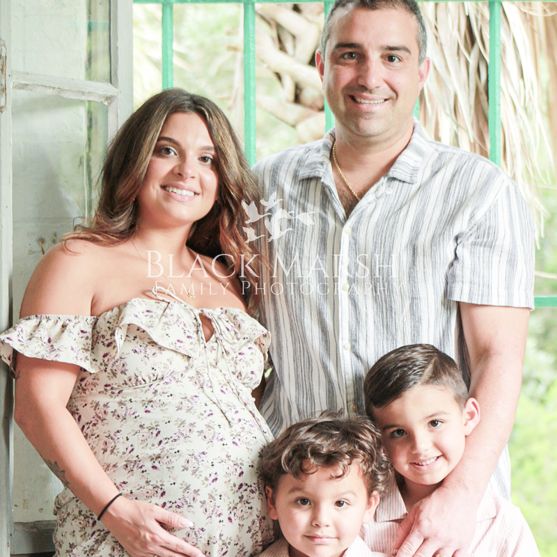 Father and mother posing with two boys at Atalaya Castle for photography session