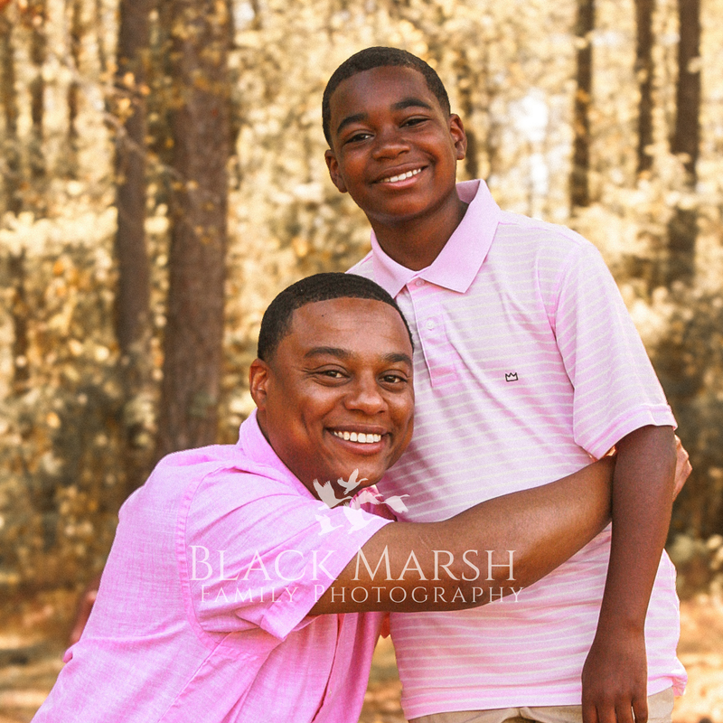 Father hugging his son and posing with woodland background